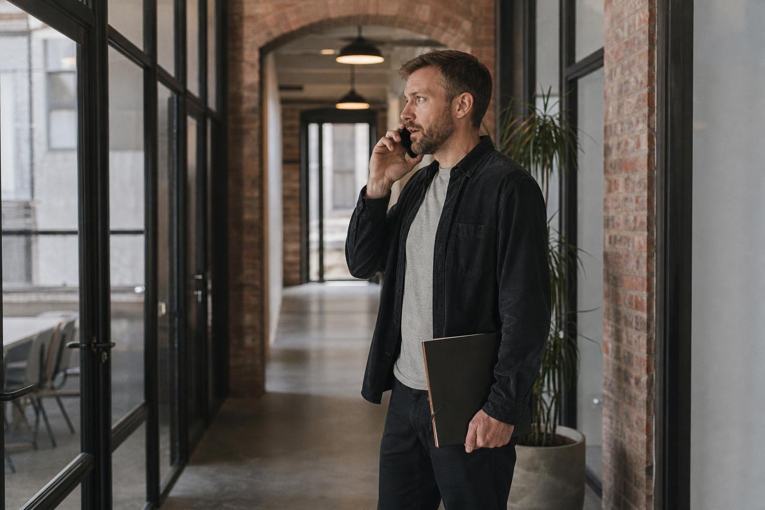 A founder taking an agency sales call in the corridor of a converted brick office